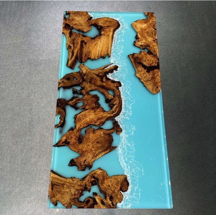 Archipelago table: islands of burl scattered in ocean resin, seen from above